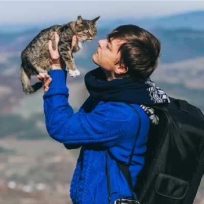 A man on a hike holding a cat